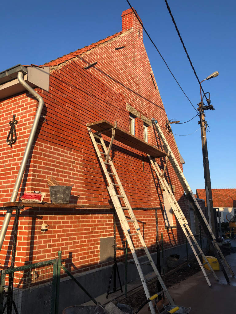 Renovatie woning Aalter zijmuur met ladders en half gevoegd